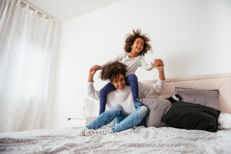 A woman and a child on the bed.